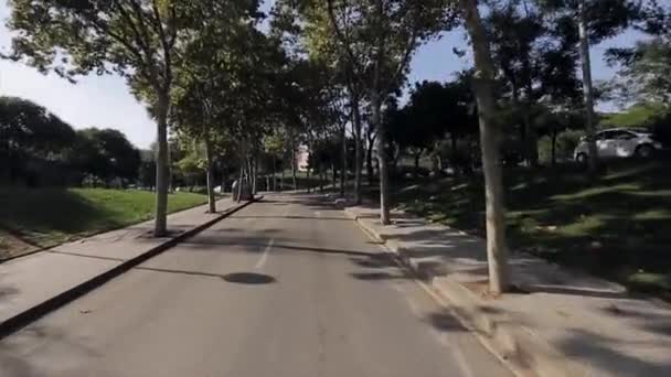 夏の晴れた日の市内の路地の緑木と道路で見る。人々。バイクの運転にカメラ - 映像、動画