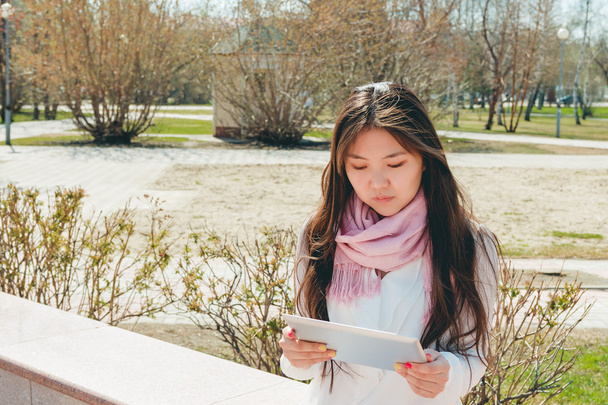 Asian woman using digital tablet in park - Foto, Imagem