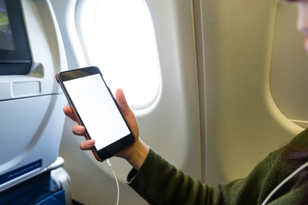 Woman using cellphone inside airplane - Фото, изображение