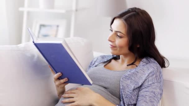 happy pregnant woman reading book at home - Video