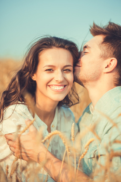 Young couple in love outdoor.Stunning sensual outdoor portrait of young stylish fashion couple posing in summer in field.Happy Smiling Couple in love.They are smiling and looking at each other - Foto, afbeelding