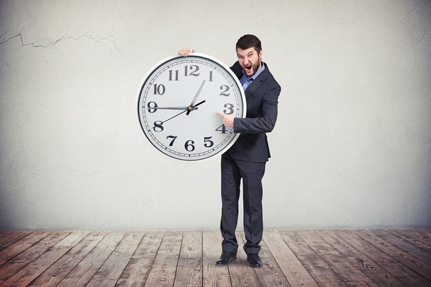 Homme d'affaires met l'accent sur le temps sur la grande horloge
 - Photo, image