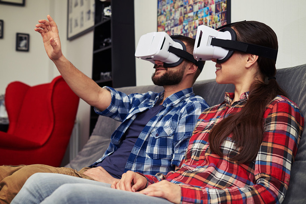 Paar mit Virtual-Reality-Brille beobachtet etwas und Mann versucht es - Foto, Bild