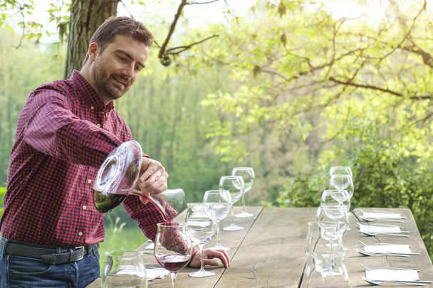 provador de vinho e copos de vinho em uma mesa de madeira ao ar livre no campo
 - Foto, Imagem