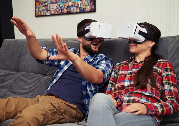Couple having fun using white virtual reality glasses - Photo, Image