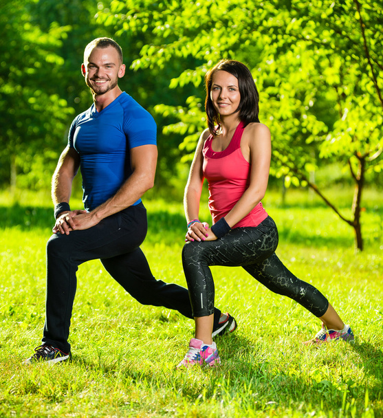 Man and woman doing stretching exercises - Fotó, kép