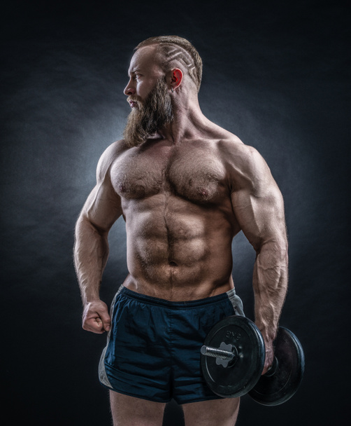 Forte fisiculturista com seis pack, abdominais perfeitos, ombros, bíceps
 - Foto, Imagem
