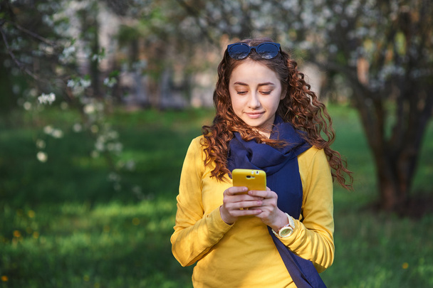 технологии и концепция людей - улыбающаяся молодая женщина смс на смартфоне
 - Фото, изображение