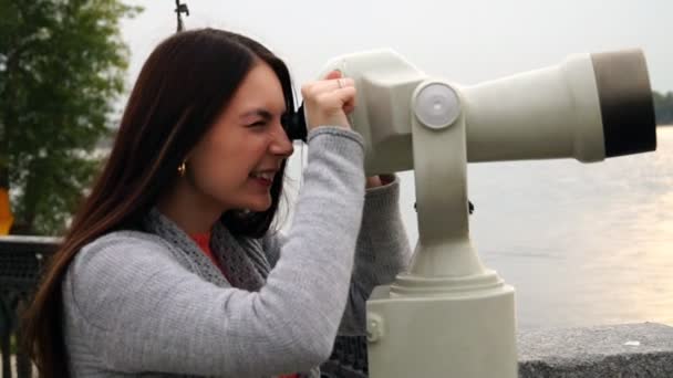 chica mira a través de prismáticos en el paseo marítimo
 - Metraje, vídeo