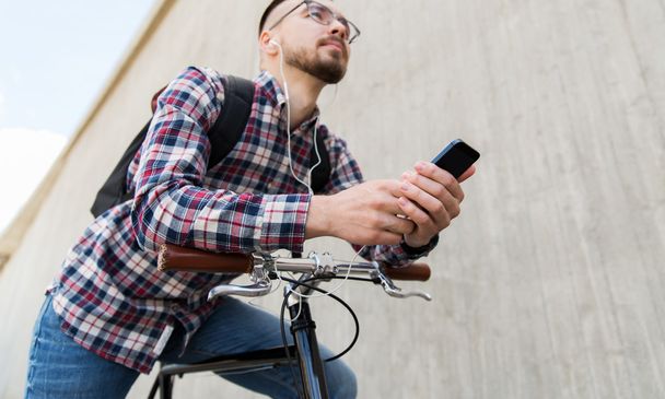 hipster man in earphones with smartphone and bike - Zdjęcie, obraz