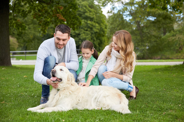 happy family with labrador retriever dog in park - Fotoğraf, Görsel