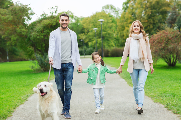 happy family with labrador retriever dog in park - Foto, Bild