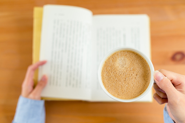 nainen lukeminen kirja ja nauttia hänen kahvia
 - Valokuva, kuva