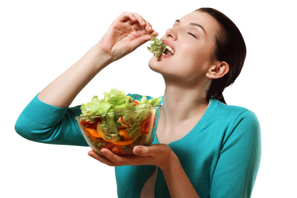 Όμορφο κορίτσι τρώει ένα νόστιμο σαλάτα από φρέσκα λαχανικά. - Φωτογραφία, εικόνα