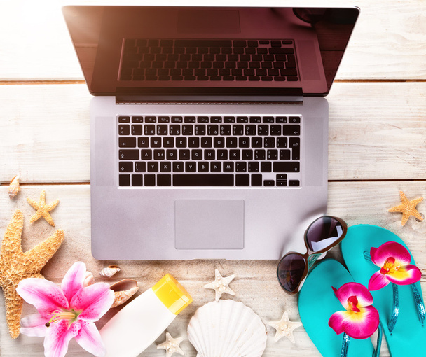 Laptop with beach accessories on wood deck - Foto, Imagem