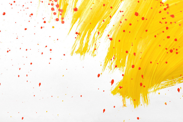 Yellow gouache smear with red splash. - Foto, afbeelding