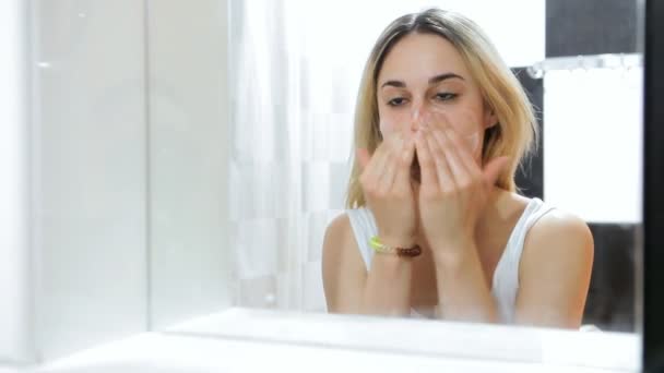 Close-up van jonge vrouw gezicht reinigen van de huid. - Video