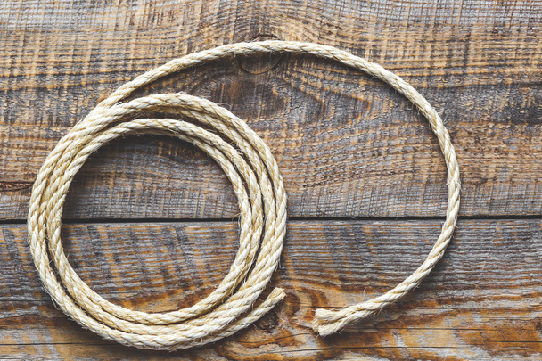 rope coiled on a wooden table - 写真・画像