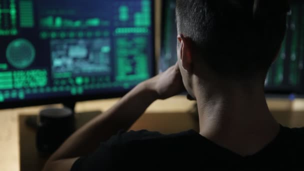 hacker works at computer with maps and data on display screens - Footage, Video