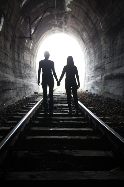 Couple walking together through a railway tunnel - Φωτογραφία, εικόνα