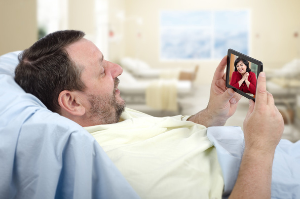 Cep telefonu kullanarak hastane yatağında sakallı adam - Fotoğraf, Görsel
