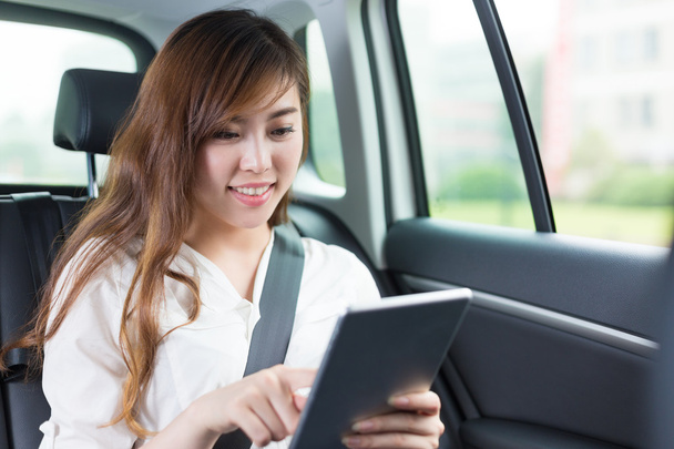 young asian girl with tablet in car - Φωτογραφία, εικόνα