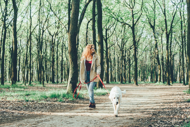 girl walking with dog in park - Foto, Bild