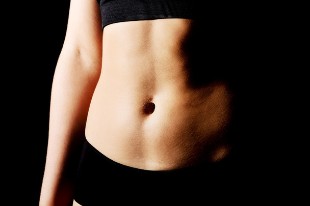 Belly of slim young woman in black sports underwear - Fotoğraf, Görsel