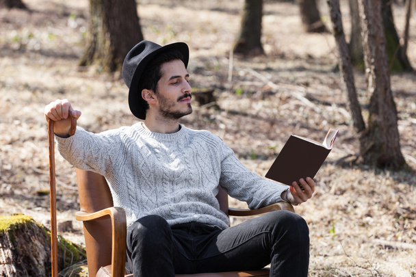 Man reading a novel in the woods - Foto, afbeelding