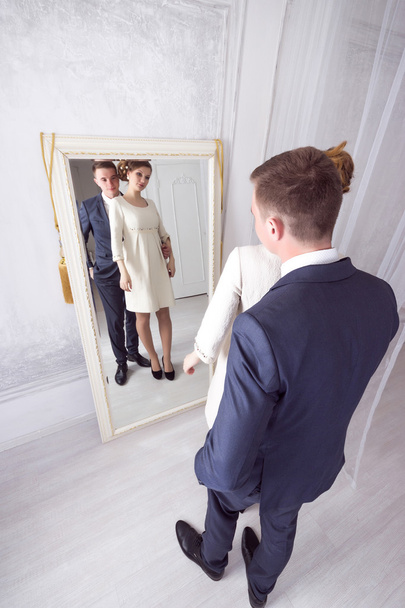 le beau jeune couple regarde et admire dans un miroir
 - Photo, image