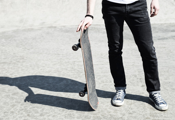 Young man holding his skate board - Fotó, kép