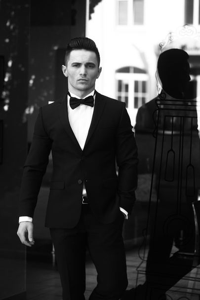 Young man in suit near glass door - Valokuva, kuva