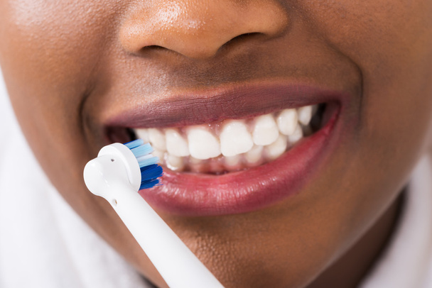 Woman Brushing Teeth With Electric Toothbrush - Фото, зображення