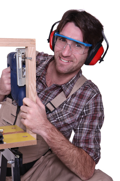 Carpenter sawing wooden frame - Фото, изображение