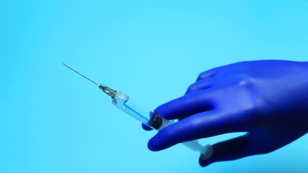 Doctor in de blauwe handschoenen plukken van een geneesmiddel in de spuit - Video