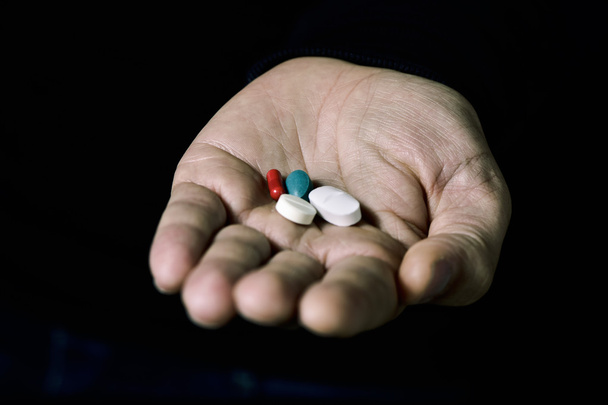 таблетки в руке молодого человека
 - Фото, изображение