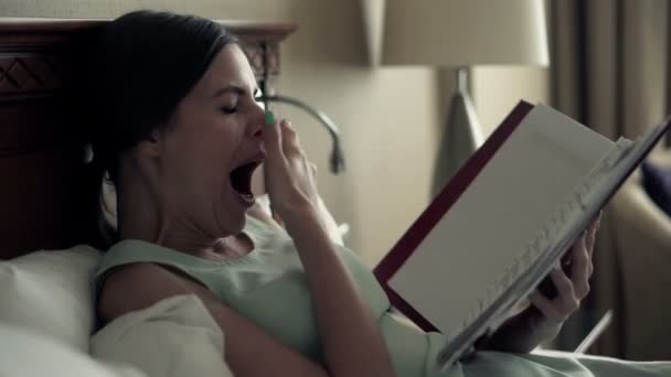 businesswoman yawning over documents in hotel room - Кадри, відео