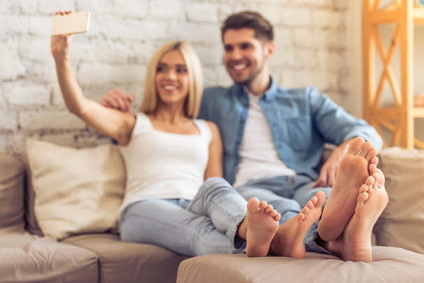 Beautiful couple at home with gadget - Photo, Image