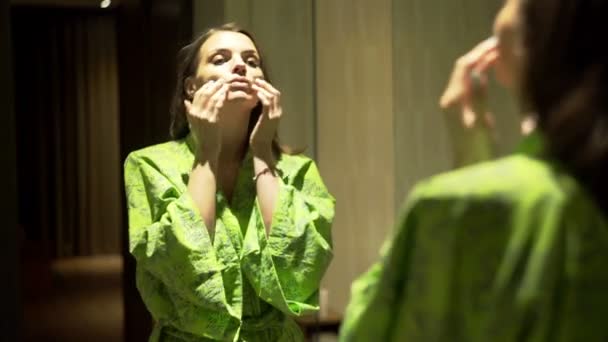 woman applying cream and doing face message in bathroom - Filmagem, Vídeo