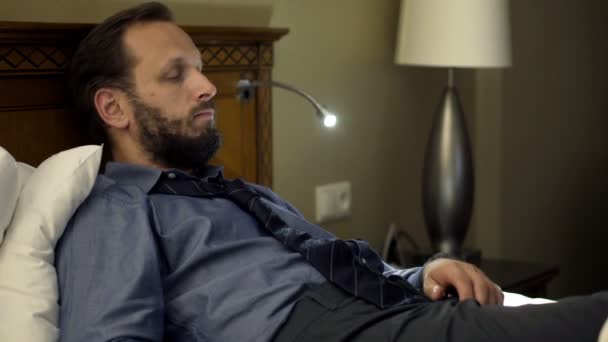 Bored businessman lying on bed at night  - Séquence, vidéo