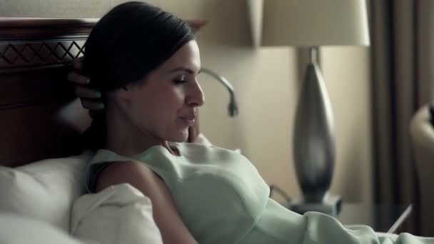 businesswoman relaxing on bed in hotel room - Felvétel, videó