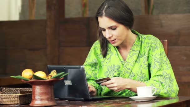 woman doing online shopping on laptop in kitchen - Video, Çekim