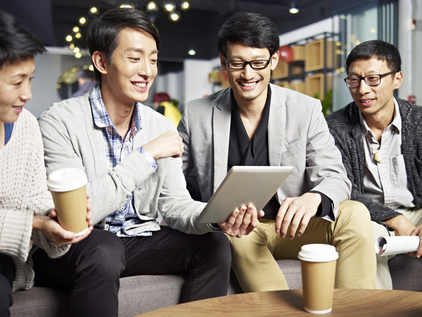 jóvenes asiático negocios personas utilizando tableta en oficina
 - Foto, imagen