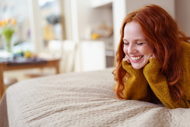 Excited young redhead woman lying grinning - Φωτογραφία, εικόνα