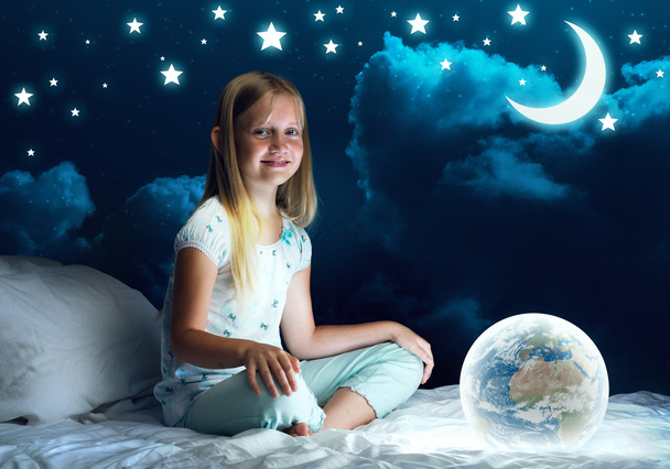 Girl in her bed and glowing globe - Photo, Image
