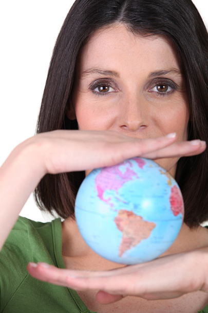 Woman holding miniature globe - Фото, зображення