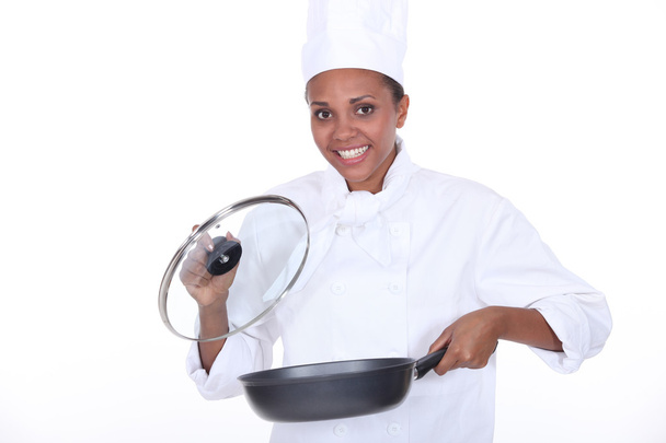 Female chef exhibits a frying pan - Zdjęcie, obraz