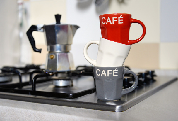 taza de café apilada y cafetera vintage en la cocina estufa
 - Foto, imagen