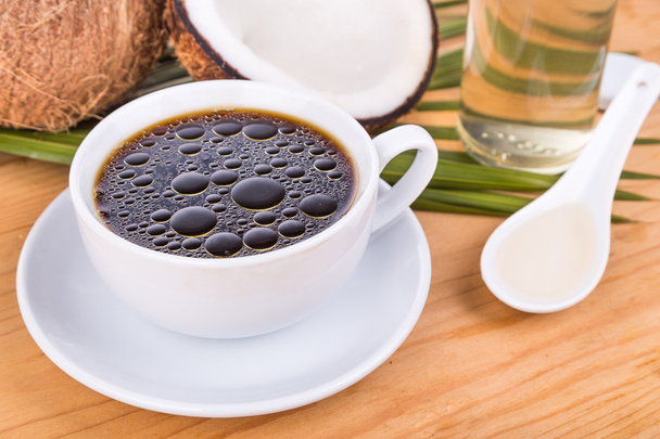 Café a prueba de balas con aceite de coco virgen sobre mesa de madera
 - Foto, imagen