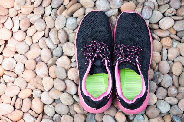 Zapatillas de correr en casa jardín sobre guijarros
 - Foto, imagen
